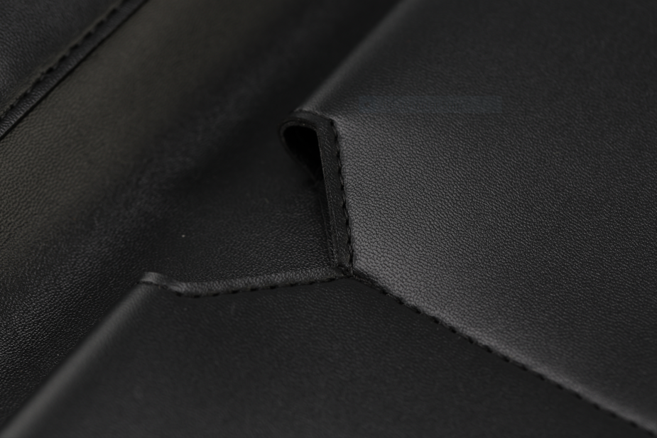 Close-up of the Brooklyn Wallet, part of the Harlem & Brooklyn Bundle by Sonia's Vokalized Kreations, highlights its black leather with visible stitching and folded corner detail—a timeless classic accessory demonstrating impeccable texture and craftsmanship.