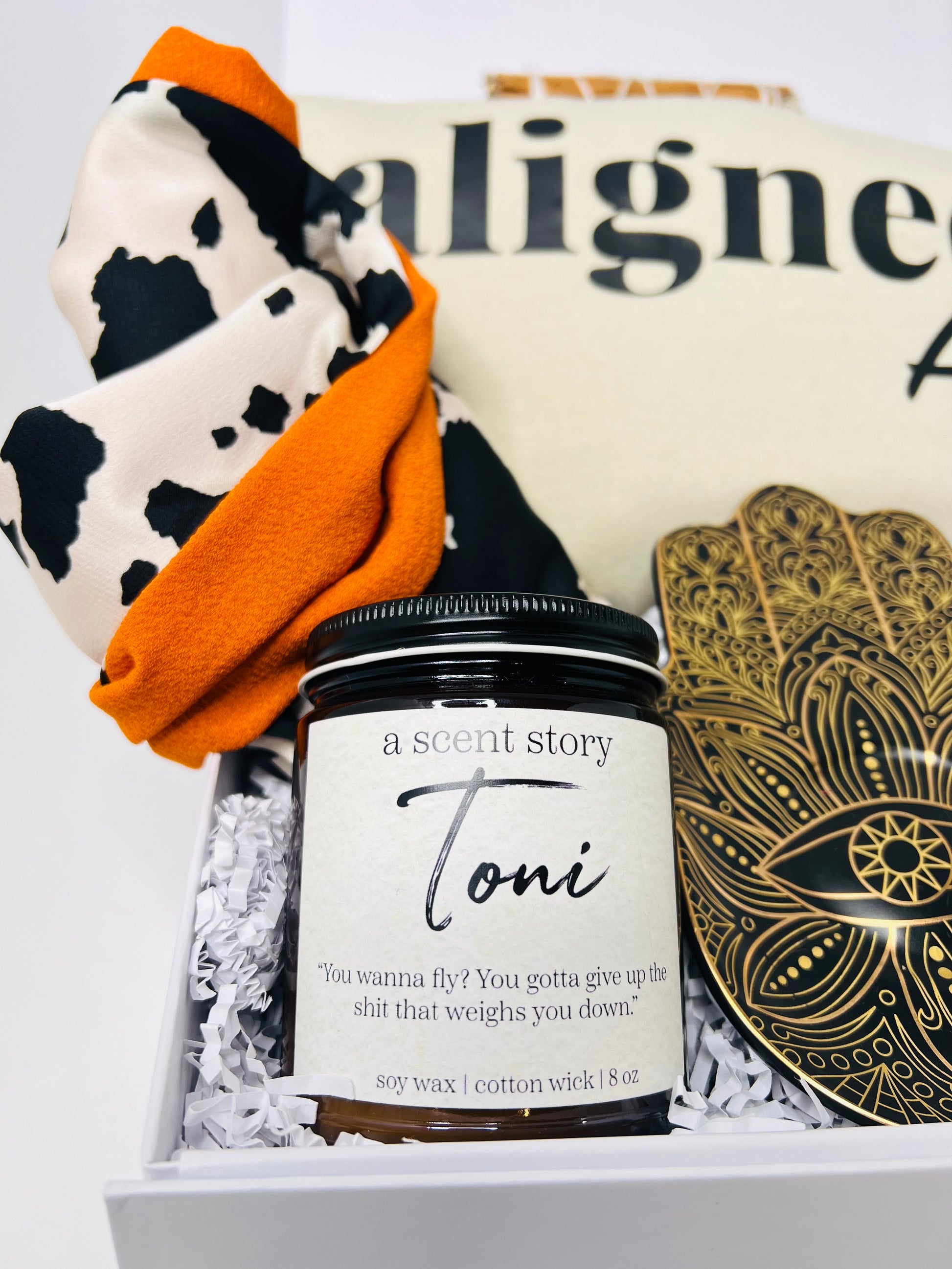 The "Don't Disturb My Peace" gift box by Sonia's Vokalized Kreations offers tranquility with a Toni candle, patterned cloth, decorative coaster, and an inspiring cream-colored fabric.