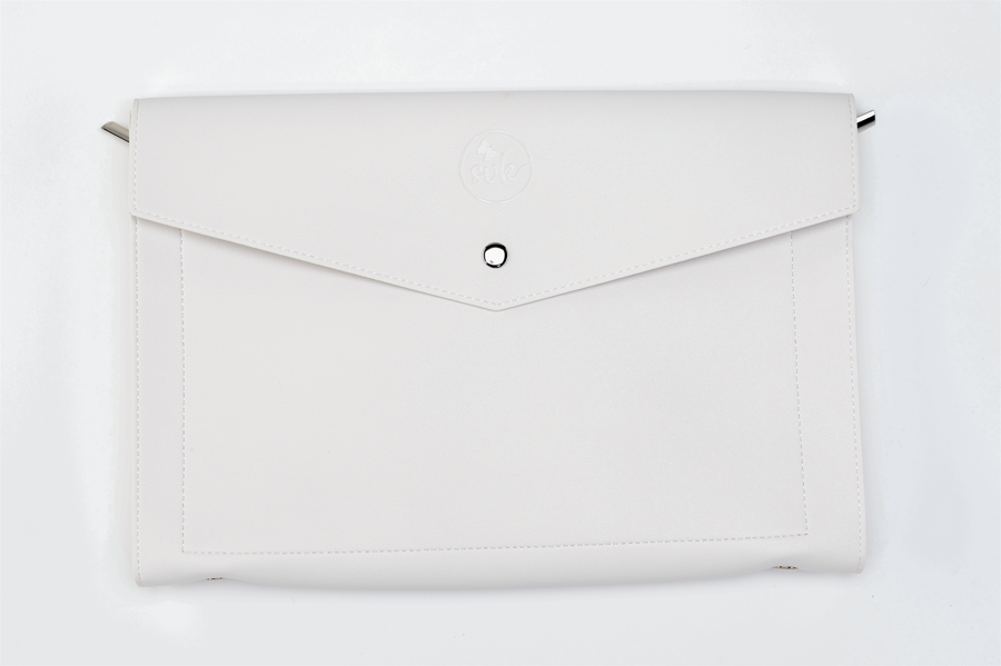 The Paloma clutch bag by Sonia's Vokalized Kreations is a bold statement piece featuring a white envelope-style design, rounded flap, button clasp, and subtle embossed logo.