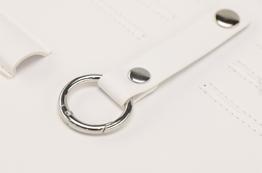 A close-up of Paloma by Sonia's Vokalized Kreations reveals a bold white leather strap accented with a metal ring and two metal studs, perfect for the fearless woman.