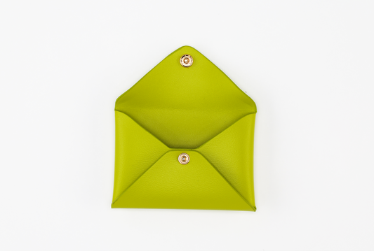 A bright green, open leather envelope pouch from the Pompei & Brooklyn Bundle by Sonia's Vokalized Kreations, reminiscent of the Pompei Clutch, features a snap button closure and is laid flat on a white background.