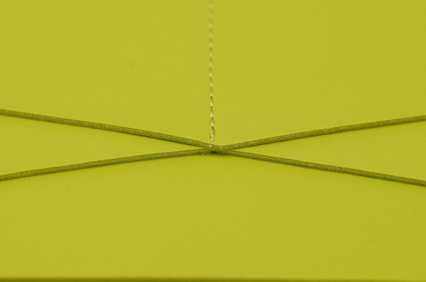A close-up of a lime green envelope with a crisscross string closure, similar to the vibrant design in the Pompei & Brooklyn Bundle by Sonia's Vokalized Kreations.