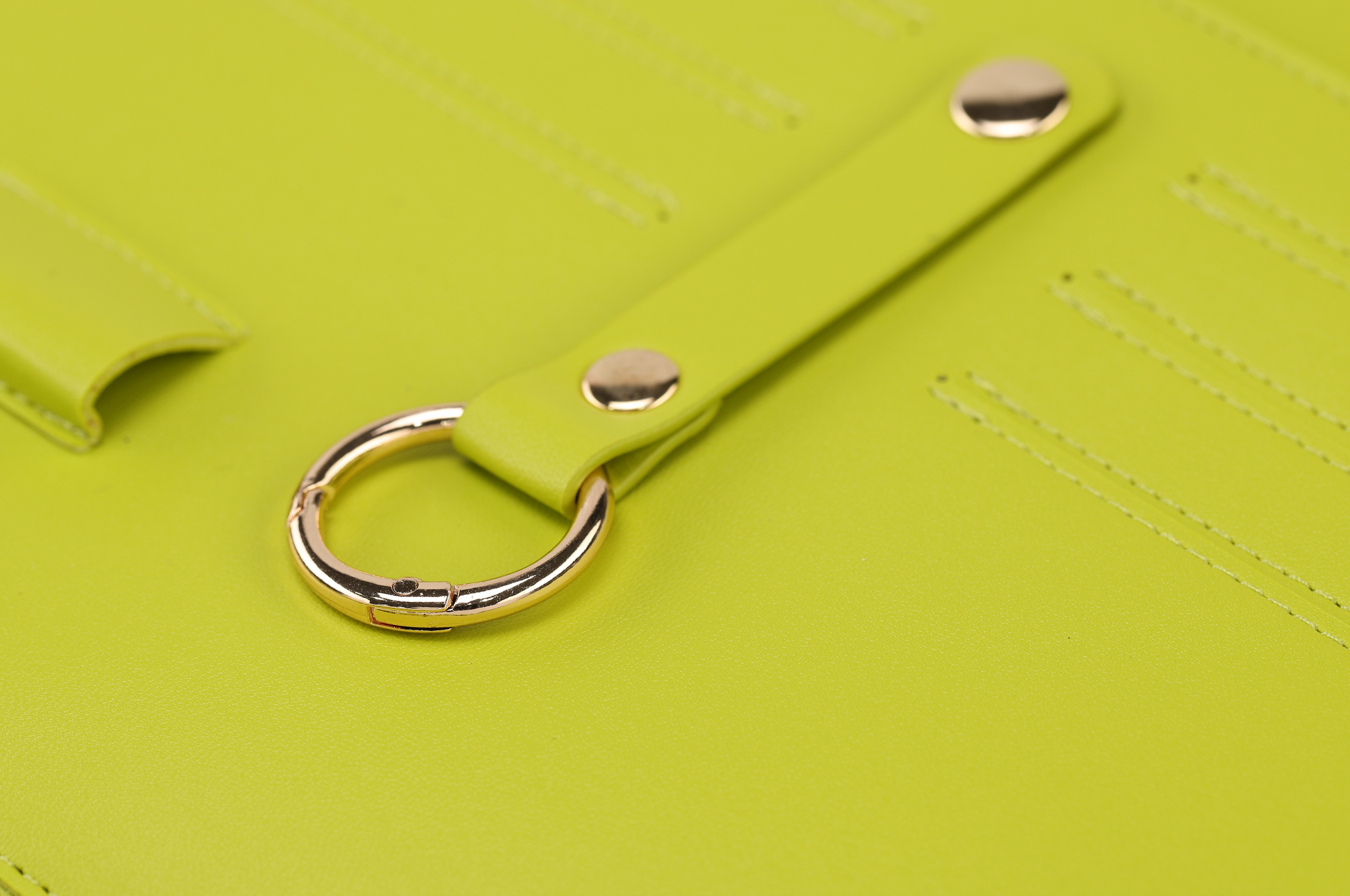 Close-up of a bright green leather clutch with a gold ring and strap featuring gold rivets, part of the Pompei & Brooklyn Bundle by Sonia's Vokalized Kreations, perfect for empowering women.
