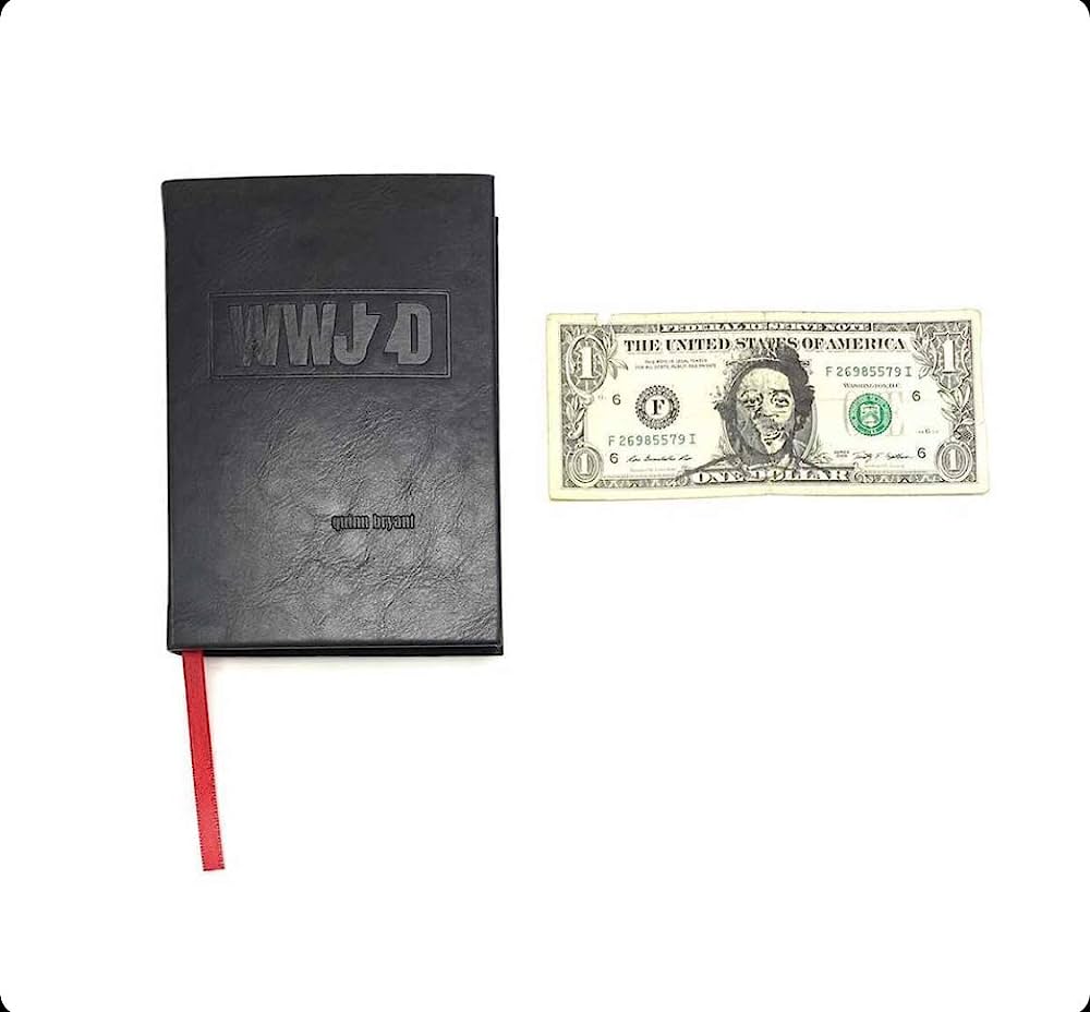 Black notebook with "WWJD" on the cover next to a U.S. one-dollar bill.