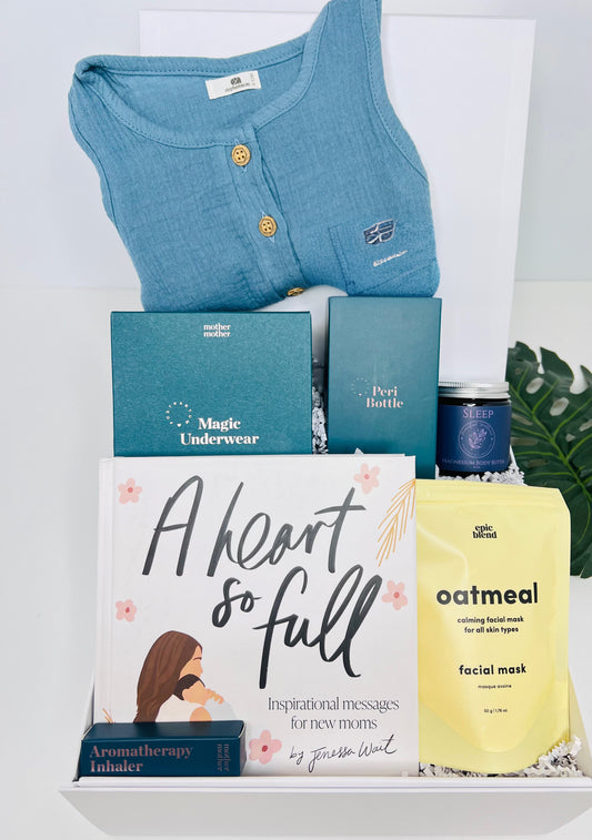 The New Baby Gift Box for Mom & Baby by Sonia's Vokalized Kreations includes a blue sleeveless top, Magic Underwear, organic jumpsuit, pearl bottle, sleep gummies, oatmeal mask, aromatherapy inhaler, and "A Heart So Full"—ideal for postpartum care.