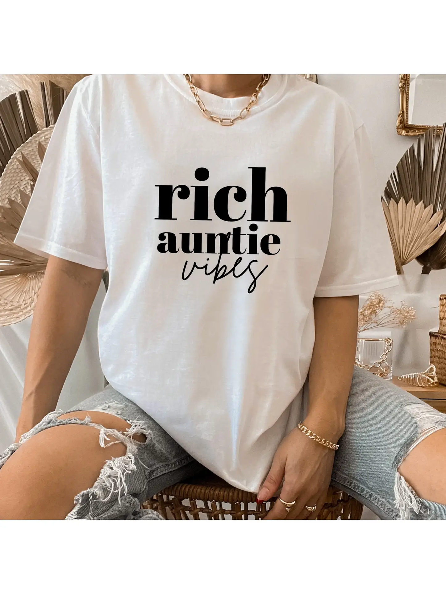 Someone is rocking a Sonia's Vokalized Kreations "Rich Auntie Vibes" T-shirt, perfectly paired with ripped jeans.