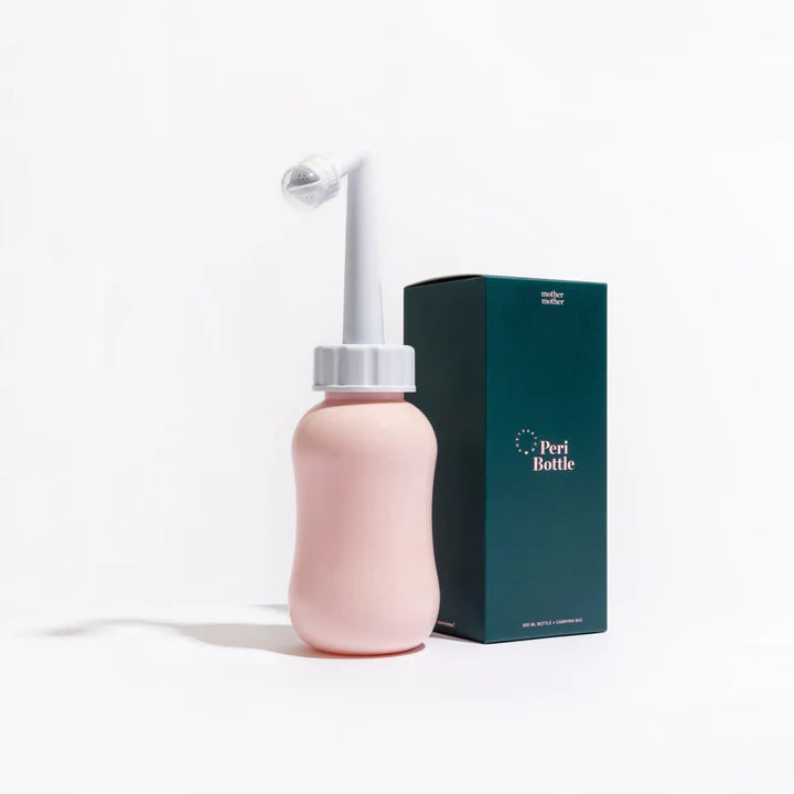 A pink peri bottle with a white angled nozzle sits beside a dark green "Peri Bottle" box—part of Sonia's Vokalized Kreations' New Baby Gift Box for Mom & Baby, an ideal choice for postpartum care or custom baby shower bundles.