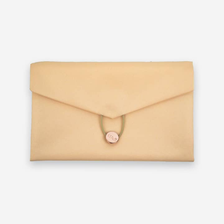 The Daily Daisy Swaddle Bag by Sonia's Vokalized Kreations is a beige fabric envelope clutch with a button and loop closure, providing both style and function.