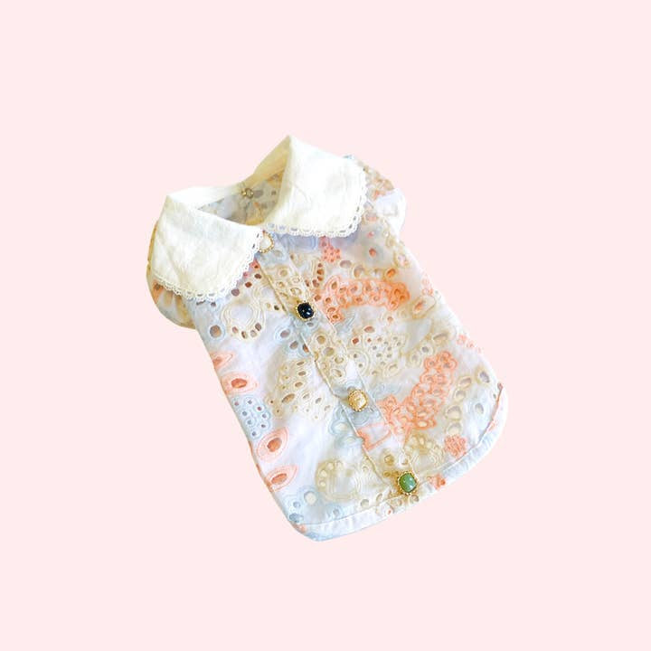 Sonia's Vokalized Kreations' pastel Summer Princess Vintage Style Handmade Pet Dress-Shirt, with a floral pattern and white collar, exudes vintage charm against a light pink background.