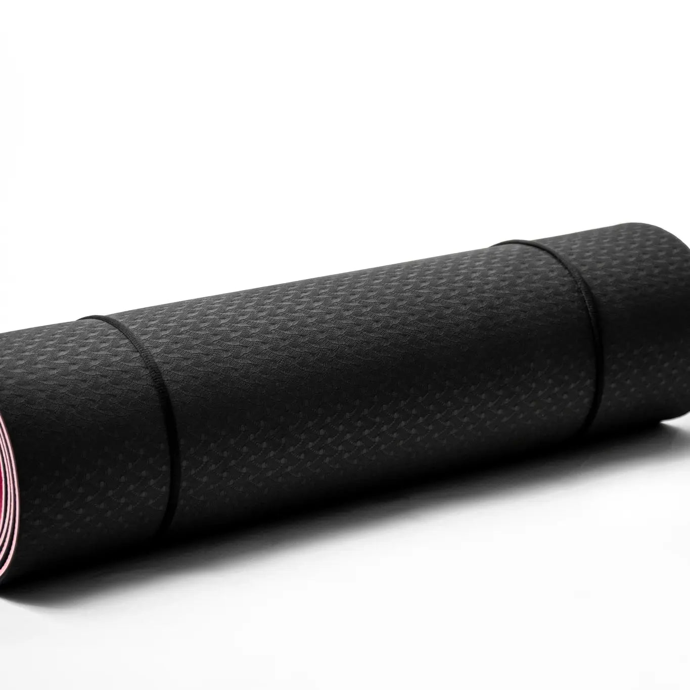 The "Inhale the Future Exhale the Past" yoga mat by Sonia's Vokalized Kreations features a black, textured surface for eco-friendly practices. It's rolled up, secured with two elastic bands, and set against a plain white background.