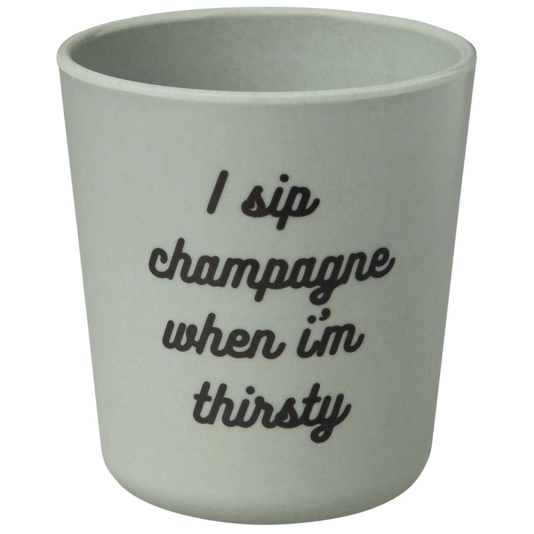 The Baby Bamboo Dinnerware Set by sonia's-vokalized-kreations features a hip-hop-inspired light green cup with black, cursive text that reads, "I sip champagne when I'm thirsty," adding eco-friendly flair to any table setting.