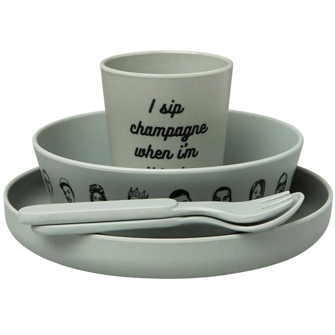 The Baby Bamboo Dinnerware Set by sonia's-vokalized-kreations is a gray, hip-hop-inspired set featuring a plate, bowl with face illustrations around the edge, cutlery, and an eco-friendly cup inscribed with "I sip champagne when I'm...