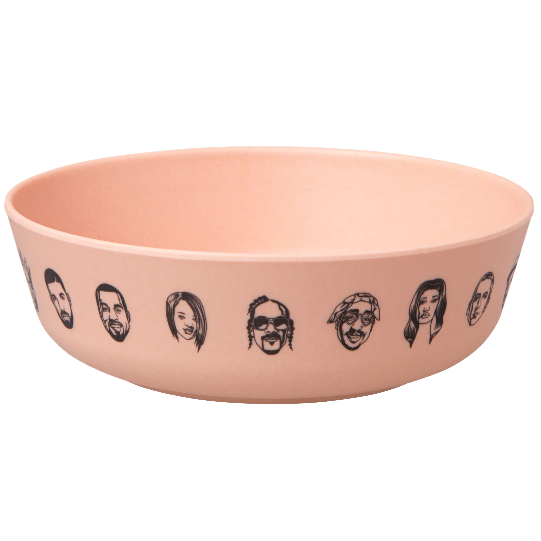 The Baby Bamboo Dinnerware Set by sonia's-vokalized-kreations includes a beige bowl adorned with illustrated faces around its exterior, designed as an eco-friendly option.