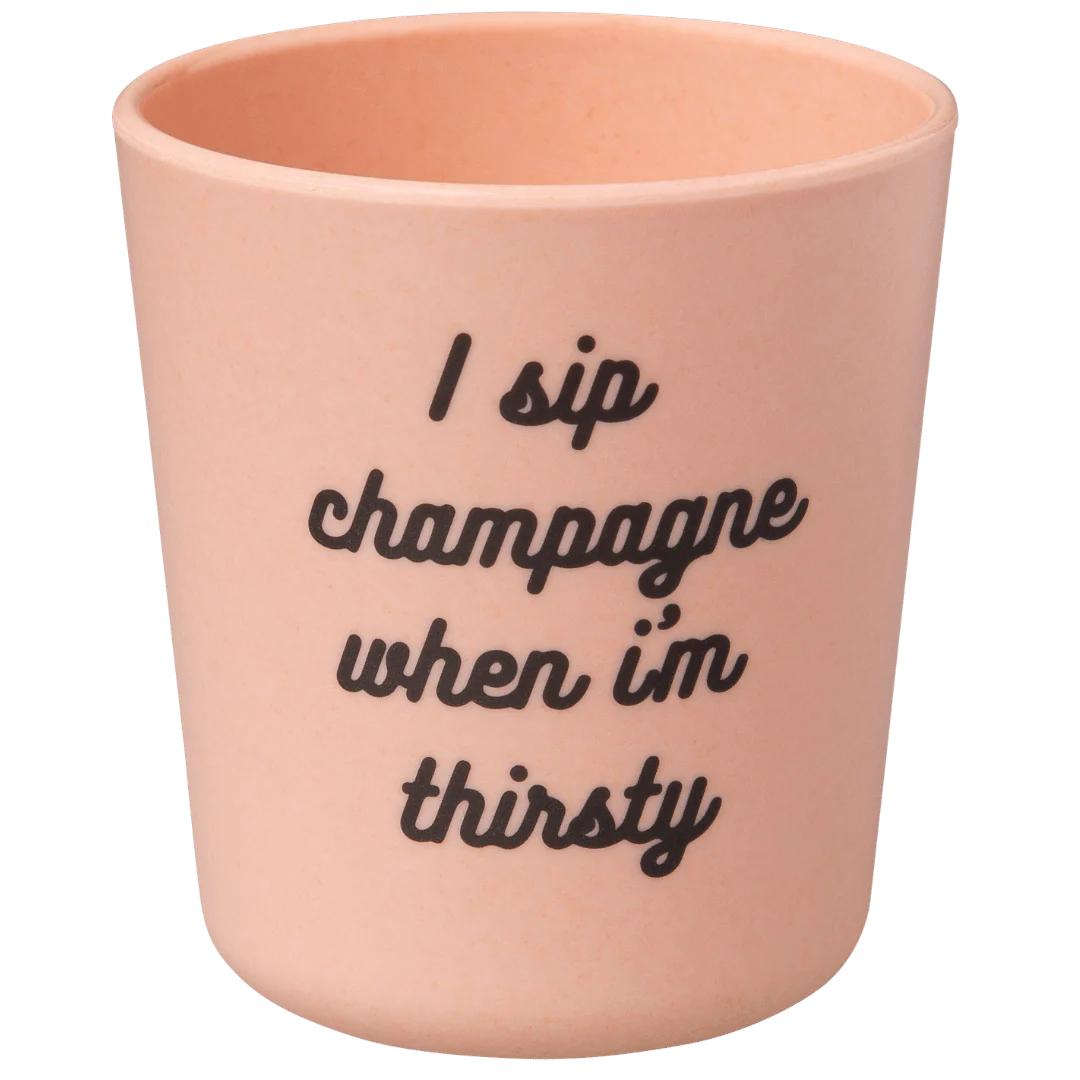 The eco-friendly Baby Bamboo Dinnerware Set in beige from Sonia's Vokalized Kreations features a cup with the black cursive phrase "I sip champagne when I'm thirsty," bringing a hip-hop flair to your collection.
