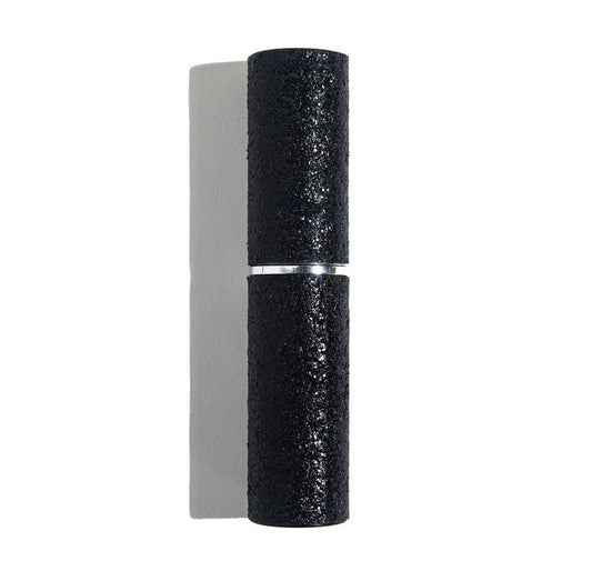 The Mini Stun Gun by sonia's-vokalized-kreations is mounted on a white wall, resembling a black cylindrical fixture with a textured surface, casting a symmetrical shadow and offering rechargeable capabilities for energy efficiency.