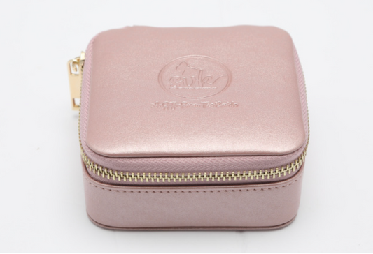 A square, pink leather travel case named "A Gift from the Bride" by sonia's-vokalized-kreations features a zippered design with embossed branding on the lid, making it an ideal bridesmaids gift, displayed against a plain white background.