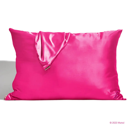A shiny, bright pink pillow with a coordinating eye mask provides beauty sleep akin to Barbie's, designed to prevent facial creases. This set radiates luxury and style as part of the exclusive Sonia's Vokalized Kreations Satin Pillowcases collection.