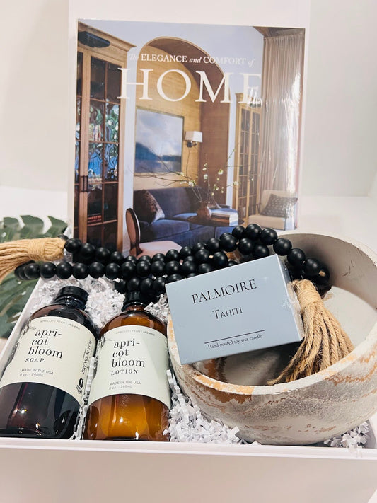 The Boho Self-Care Home Gift Box by Sonia's Vokalized Kreations features HOME magazine, apricot bloom soap and lotion, a Palmoire Tahiti soy candle, beaded tassel, and ceramic bowl—beautifully packed for thoughtful self-care.