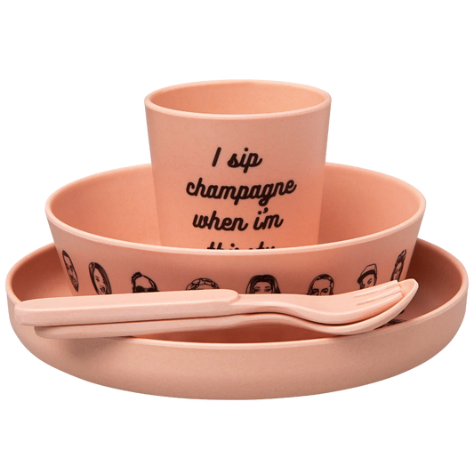 Sonia's-vokalized-kreations' Baby Bamboo Dinnerware Set includes a hip-hop inspired pink cup, bowl, plate, fork, and spoon with illustrated faces. Made from eco-friendly bamboo, the cup features the phrase "I sip champagne when I'm thirsty.